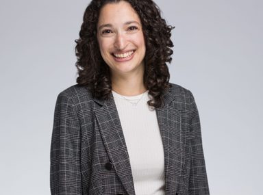 A diverse crowd of people celebrating at a concert, raising their hands and cheering.