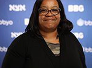 A diverse crowd of people celebrating at a concert, raising their hands and cheering.