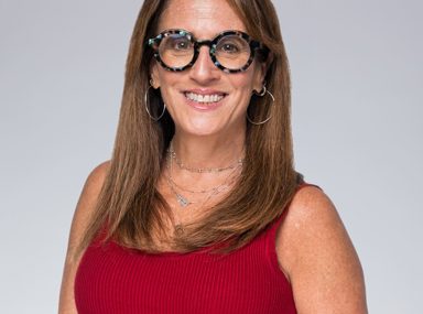 A diverse crowd of people celebrating at a concert, raising their hands and cheering.