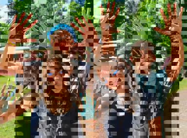 A diverse crowd of people celebrating at a concert, raising their hands and cheering.