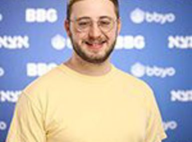 A diverse crowd of people celebrating at a concert, raising their hands and cheering.