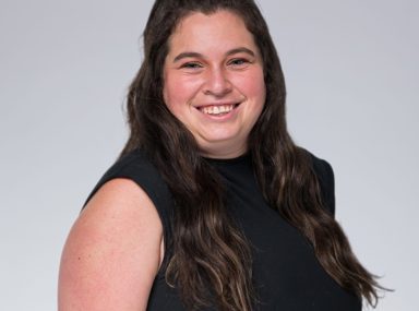 A diverse crowd of people celebrating at a concert, raising their hands and cheering.