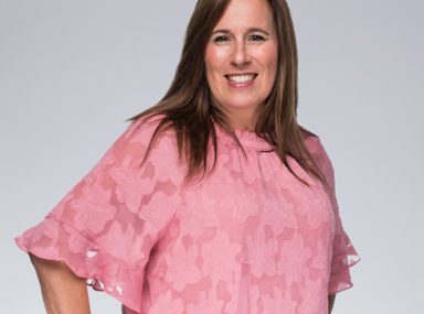 A diverse crowd of people celebrating at a concert, raising their hands and cheering.