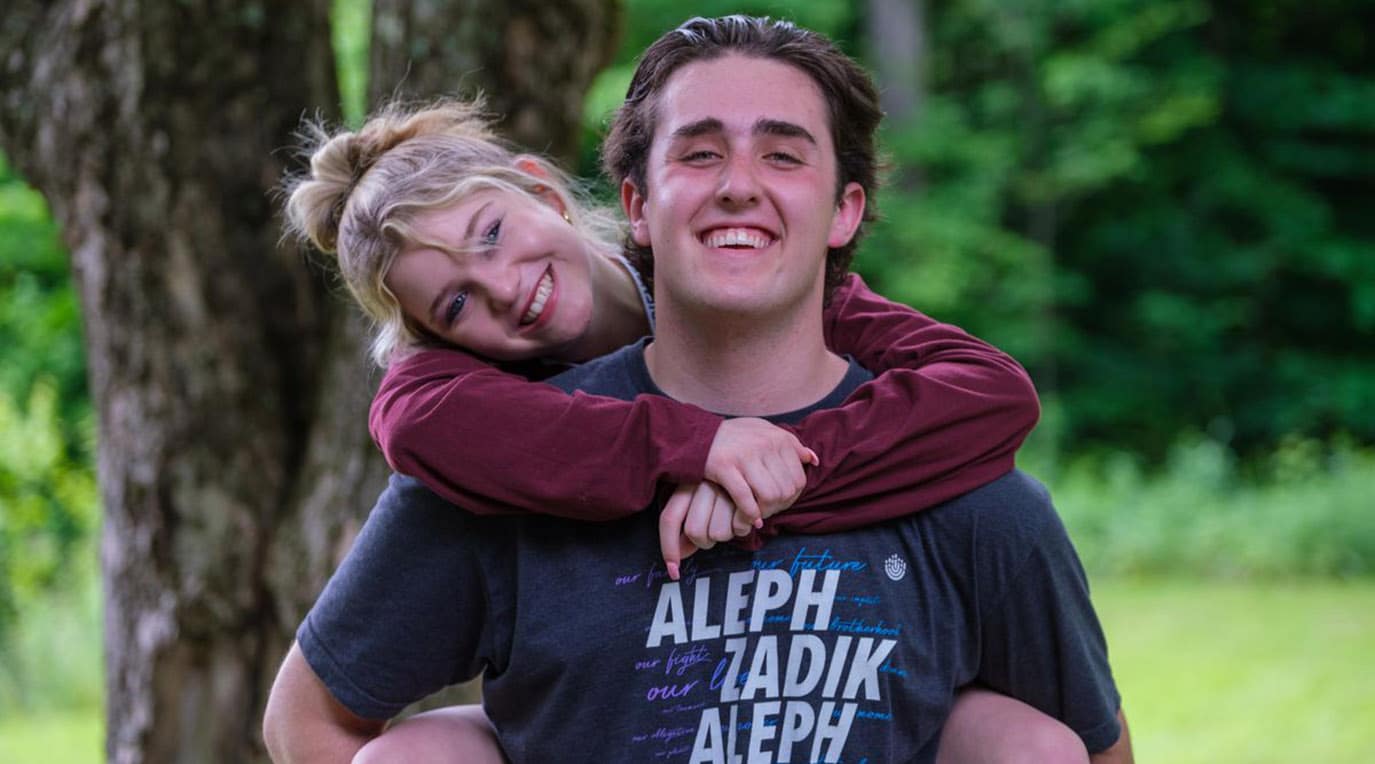 A diverse crowd of people celebrating at a concert, raising their hands and cheering.