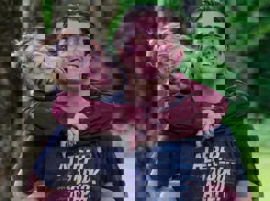 A diverse crowd of people celebrating at a concert, raising their hands and cheering.