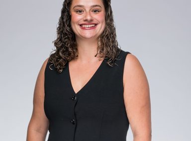 A diverse crowd of people celebrating at a concert, raising their hands and cheering.