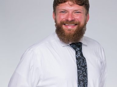 A diverse crowd of people celebrating at a concert, raising their hands and cheering.
